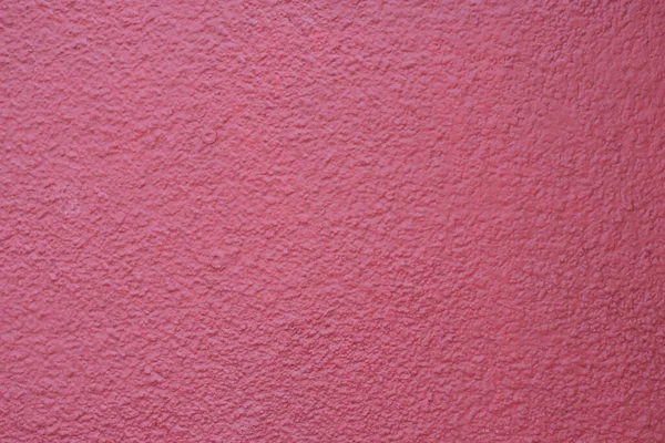 Canlı pembe duvar, zengin bir doku ve derinlik sergiliyor..