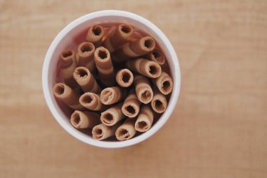 Yuvarlanmış gofretler bir fincanda güzelce sıralanır. Atıştırmak için birebirdir..