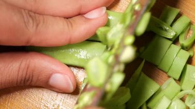 Sağlıklı yemekler için taze sebzeleri doğrarken yakın plan çekimler..