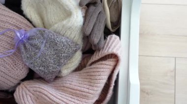 Yumuşak kazaklar, eldivenler ve lavanta kesesi kış konforu için bir çekmeceyi doldurur..