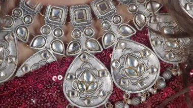 Çarpıcı gümüş kolye, canlı kırmızı bir arkaplan ile eşleştirilmiş..