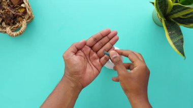 Bir insan eline parlak bir yüzeye nemlendirici krem sürer..