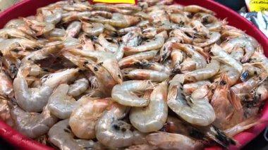 Taze karides, sabahın erken saatlerinde kalabalık bir markette büyük bir kırmızı kaseyi doldurur..