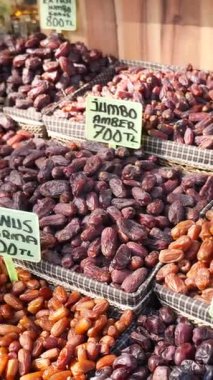 Hareketli bir pazar standında gösterilen renkli tarih çeşitleri.