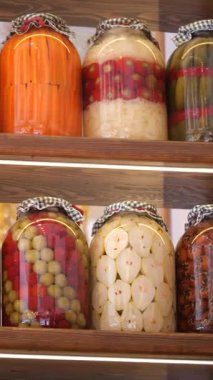 Raflarda düzgünce yerleştirilmiş ev yapımı konserveleri araştırın..