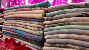 Yığınla renkli ve desenli kumaşlarla dolu canlı bir pazar keşfedin..
