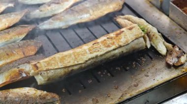 Taze balık, canlı bir açık hava pazarında sıcak bir yüzeyde kızartılır..