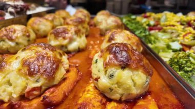 Aşçılar yoğun bir pazarda lezzetli soslu lezzetli köfteler hazırlarlar..