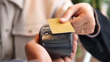 Müşteri kartlarını bir kafede ödeme cihazına takar..