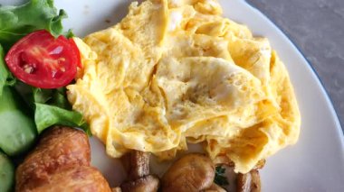 Tüylü bir omlet, mantar ve salatadan oluşan sağlıklı bir kahvaltıda iyi eğlenceler..