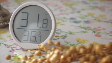 Dijital ekran sıcak bir evde sıcaklık ve nem seviyelerini gösterir.