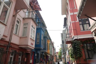 Güneşli bir günde tarihi bir bölgede renkli binaların olduğu dar bir sokak..