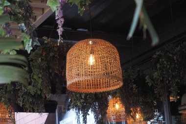 Sıcak bir kafede tavandan sarkan örülmüş fenerler var..