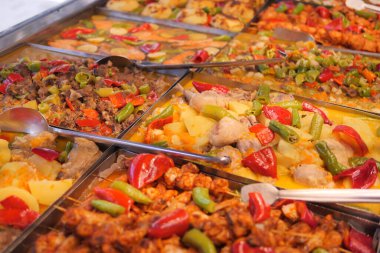 Bir büfede çeşitli ızgara etler ve sebzeler düzenlenir..