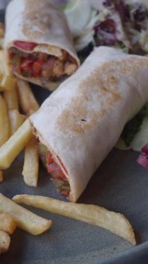 Kızarmış patates ve taze salatayla servis edilen lezzetli tavuğun tadını çıkarıyorum..