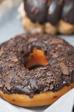 Çikolata taneli bir çörek tepside oturur..