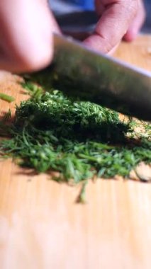 Şef yemek pişirmek için kesme tahtasının üzerinde canlı bitkiler hazırlar..