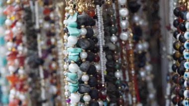 Renkli boncuk kolyeler bir pazarda benzersiz tasarımlar sergiliyor.