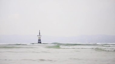 Garda Gölü Manzarası. Sisli bir sabah manzarası bir işaret direğini ve Kuzey Doğu İtalya 'daki Garda Gölü' nü geçiyor..