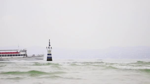 当渡船和旅游船经过加尔达湖的一个界标柱前 可以看到朦胧的晨景 锡尔敏位于意大利东北部湖的南端 — 图库视频影像
