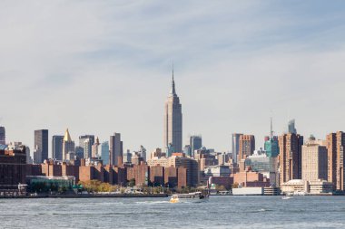 Manhattan 'ın göbeğinde New York, East River' dan izleniyor. Empire State Binası çevredeki binaların üzerinde duruyor..