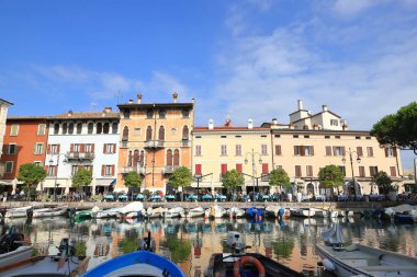 Desenzano tatil köyünde kafelere ve restoranlara demirlemiş teknelerin karşısındaki manzara. Desenzano Kuzey Doğu İtalya 'da Garda Gölü kıyısında..