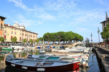 Desenzano tatil köyünde kafelere ve restoranlara demirlemiş teknelerin karşısındaki manzara. Desenzano Kuzey Doğu İtalya 'da Garda Gölü kıyısında..