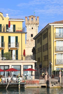 Sirmione rıhtımındaki binalardan Scaligero Kalesi 'ne olan manzara. Sirmione, İtalya 'da Garda Gölü kıyısında bir tatil köyüdür.