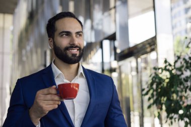 Kafede kahve içen yakışıklı bir genç fotokopi odasına bakıyor. Orta Doğulu genç işadamının portresi. İçki bardağını tutuyor, modern ofiste planlamaya başlıyor. Kahve molası