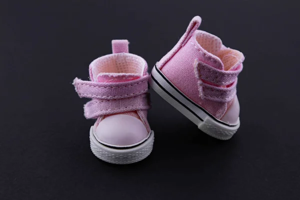 Pink baby shoes on a gentle pink background. The concept of the first steps, birthday, expectation, pregnancy, motherhood, motherhood, fatherhood. banner