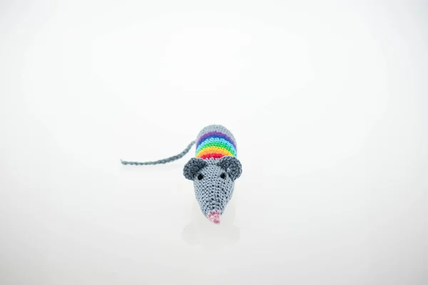 Fare bebek örüyorum. Kavram: Doğu takvimine göre sıçan yılı. Bebek beyaz bir arka planda elle örülmüş. Fare oyuncağı. Minyatür tığ işi. Metnin için kopyalama alanı ile.