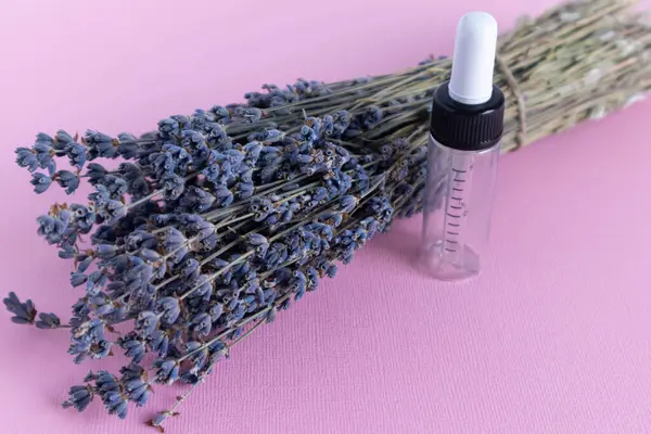Lavanta yağı, pembe üzerine lavanta çiçeği serumu. Cilt bakım ürünleri. Doğal spa güzellik ürünleri. Lavanta yağı, serum, vücut yağı, masaj yağı, sıvı.
