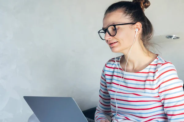 young tutor woman in eyeglasses having video call working on laptop remotely home. online distance education at quarantine self isolation. student talking with teacher.