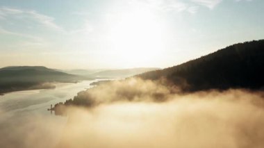 Atmospheric 4K drone footage showcasing thick fog drifting across a lush mountain forest, creating a mysterious and cinematic aerial landscape. The misty trees and rolling clouds highlight the beauty of untouched wilderness, offering a dramatic.