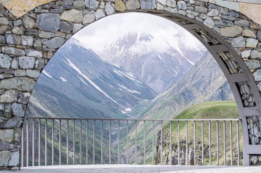 Gudauri manzaralı, parmaklıklı ve çerçeveli dramatik Kazbegi ulusal park dağları olan bir anıt. Gürcistan Macerası.