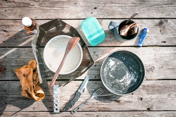 Cooking equipment on the campsite stands on grey wooden table. Holiday camp backgroud image.