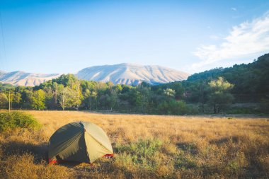 Arnavutluk 'un kırsal kesiminde yeşil el değmemiş doğa tarafından desteklenen bir çadır. Balkanlar 'da vahşi kamp.