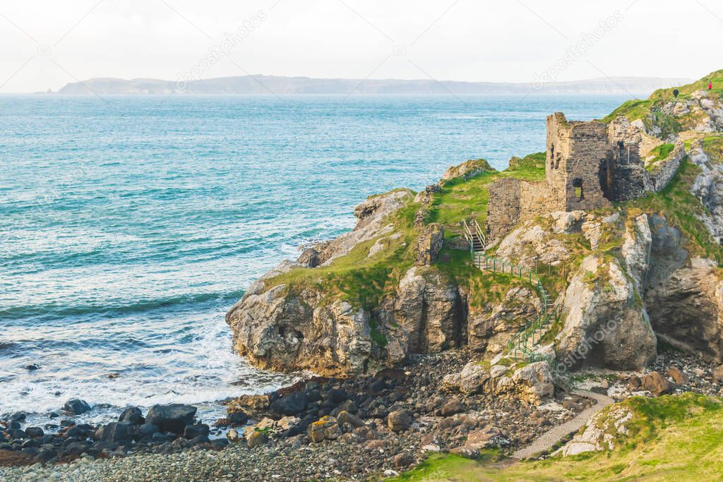 kinbane castle ruins in northern ireland coast with calm blue sea in background