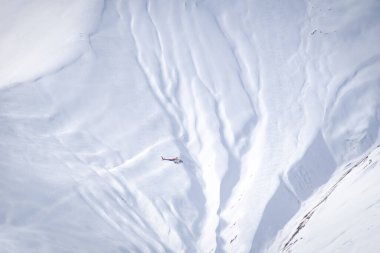 Dağları kurtarma helikopteri arka planda dev dağlarla uçuyor. Dağlarda güvenlik ve kurtarma. Gudaura.Georgia.2020