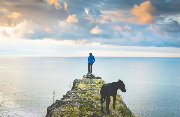 Person Dog Stands Edge Looks Sides Sea Dramatic Sky Backgrond — Stock Photo, Image