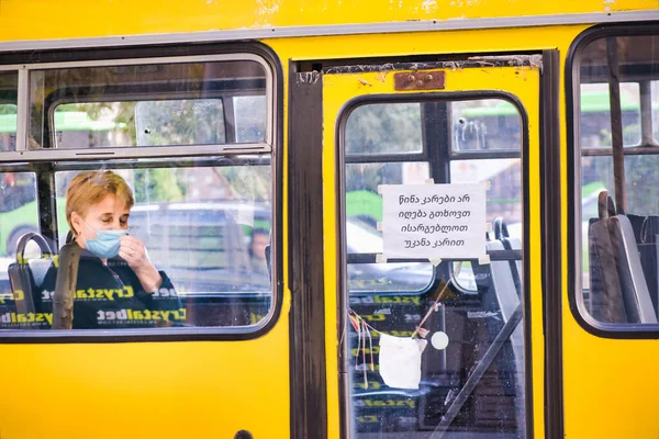 Frau Berührt Gesichtsmaske Während Sie Allein Gelben Bus Sitzt Pandemie — Stockfoto