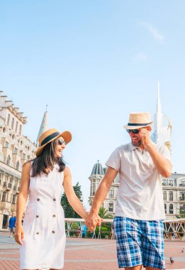 Mutlu beyaz çift Avrupa meydanında yürürken tatilde Batumi şehrini gezerken eğleniyor - tatilde birlikte gülen mutlu arkadaşlar - insanlar ve yaz tatilleri konsepti