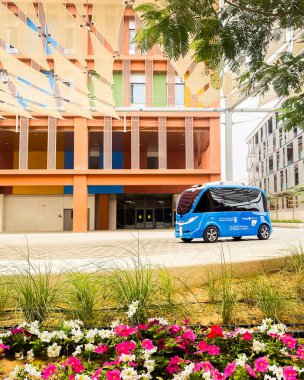 BAE, Abu Dabi - 13 Mart 2023: Masdar City 'deki otomatik servis otobüsü Abu Dabi BAE gelecekteki sürdürülebilir akıllı hareketliliği simgeliyor
