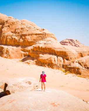 Dubai şehir merkezindeki Burj Khalifa 'ya bakarken, güneş şapkalı ve dokuma çantalı bir kadın yolcunun düşük açılı fotoğrafı. Temiz gökyüzü ve bolca kopya uzay ideali yolculuğu, lüks alışveriş