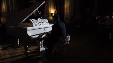 Bir piyanistin seyirci arka planında kendi müziğini icra edişi. Gece kulübünde klasik ve caz müzik konseri