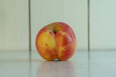 Siyam ikizleri evdeki beyaz kırsal masaya yansıyor. Organik meyve diyet için iyidir, çünkü çok fazla vitamin ve mikro element içerir. Kopya alanı olan manzara yönelimli resim.