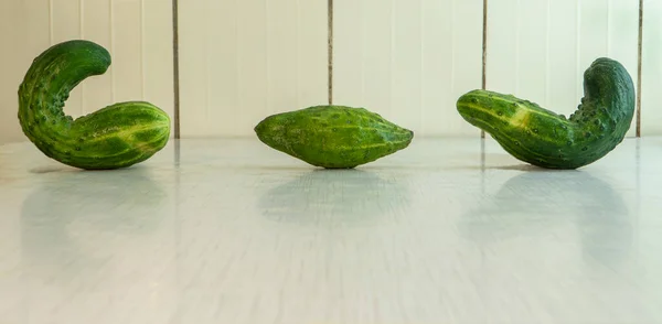 Drie Misvormde Komkommers Met Gele Strepen Liggen Rustieke Tafel Natuurlijke — Stockfoto