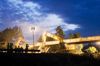 Olsany Çek Cumhuriyeti 16 Haziran 2018 Karayolu Köprüsü yıkım gece sahne. Hightway imar sitesi reflektör, ışıklar. Ağır Ekskavatör ve kazma bir beton köprü yıkmak.