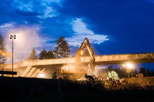 Olsany Çek Cumhuriyeti 16 Haziran 2018 Karayolu Köprüsü yıkım gece sahne. Hightway imar sitesi reflektör, ışıklar. Ağır Ekskavatör ve kazma bir beton köprü yıkmak.