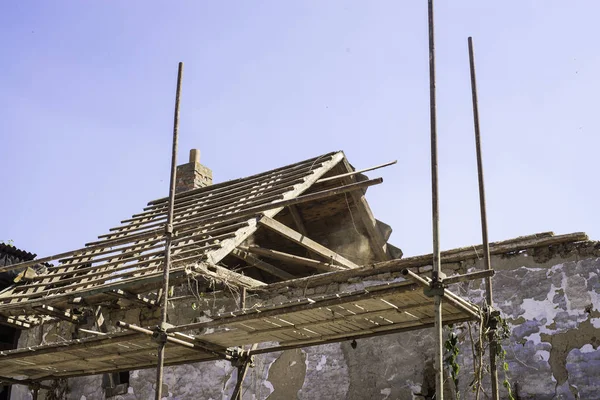 Litovel, República Tcheca 3 de agosto de 2018, andaime em pé junto a uma casa de barro em reconstrução. Construção de telhado e madeira sem telhas. Metade do telhado soprado pelo vento . — Fotografia de Stock